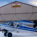 aviation repair blue and white plane in front of dan's repair hanger